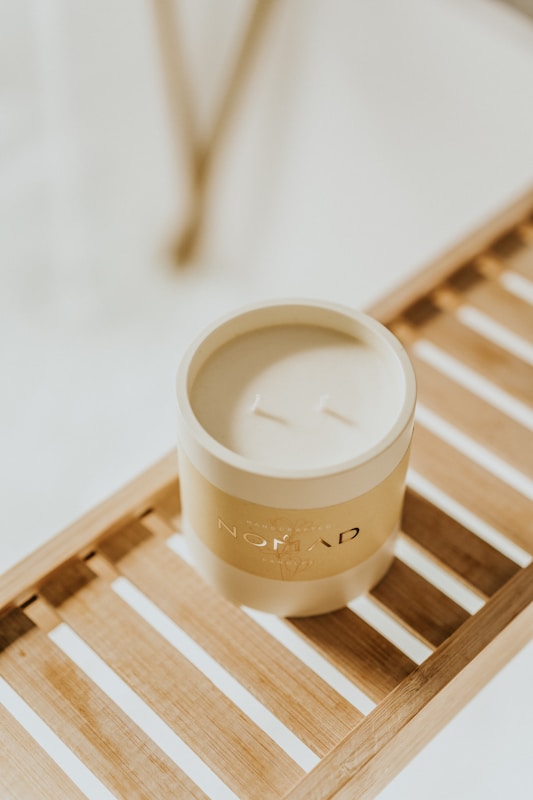 a white cup sitting on top of a wooden tray